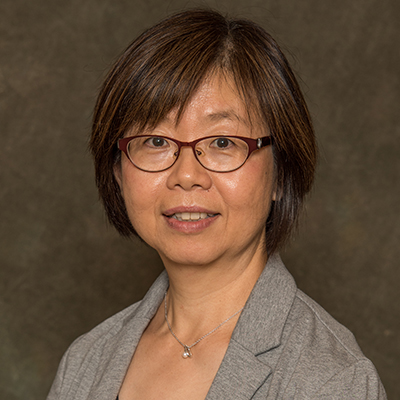 A headshot of Horng-Shiuann Wu smiling wearing glasses and a gray blazer with a necklace