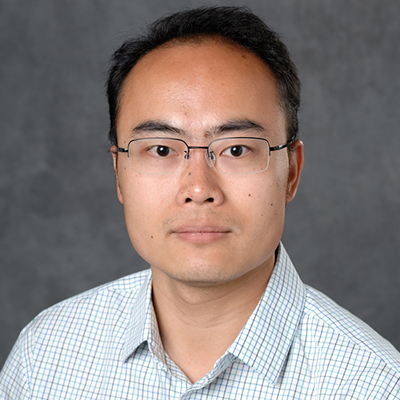 A headshot of Jianrong Wang wearing glasses with a plaid button up