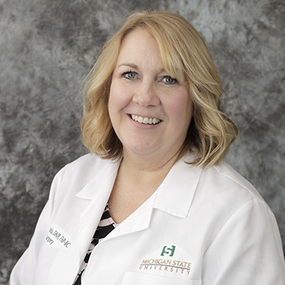 A headshot of Mary Smania smiling wearing a white lab coat