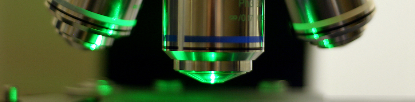 A microscope with green light bouncing off of it