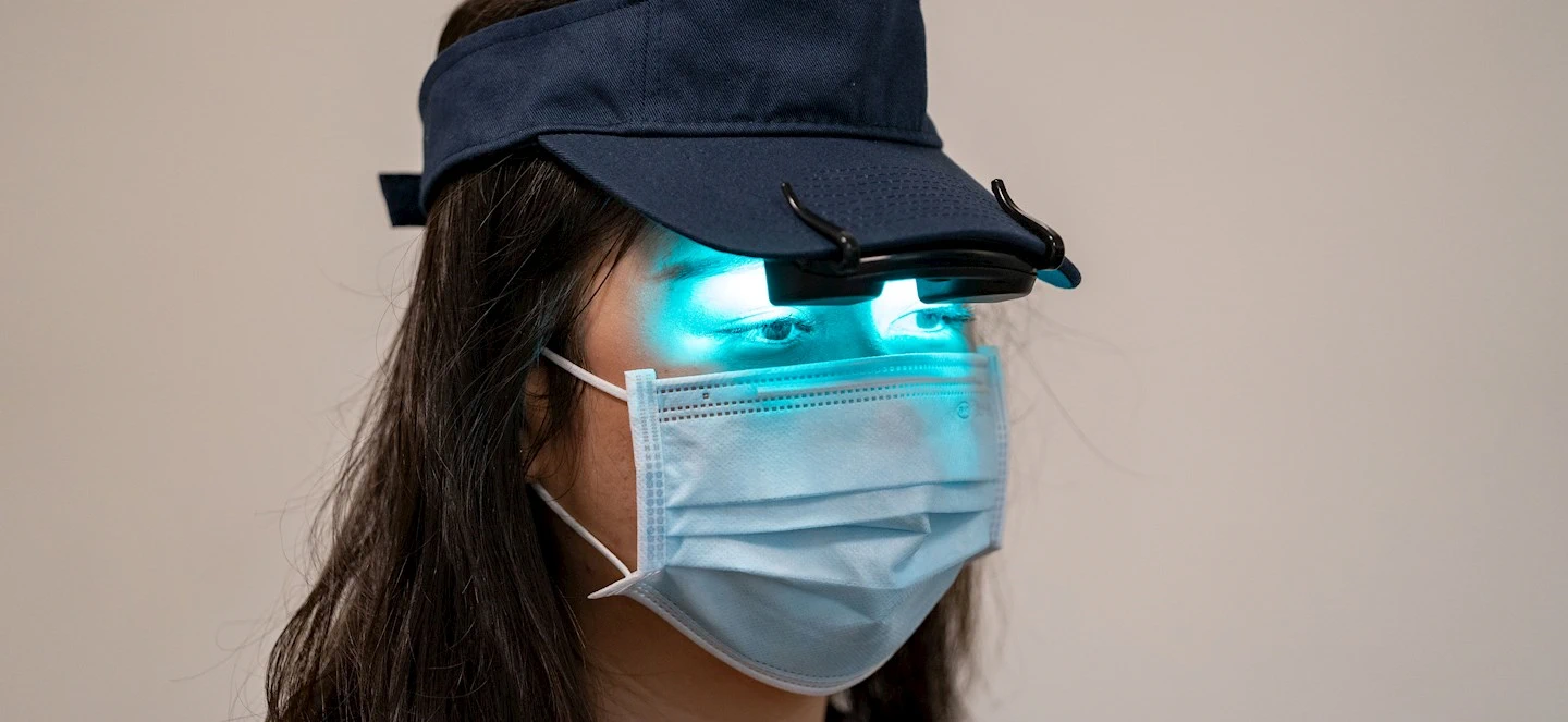 A person wearing a light therapy visor and mask