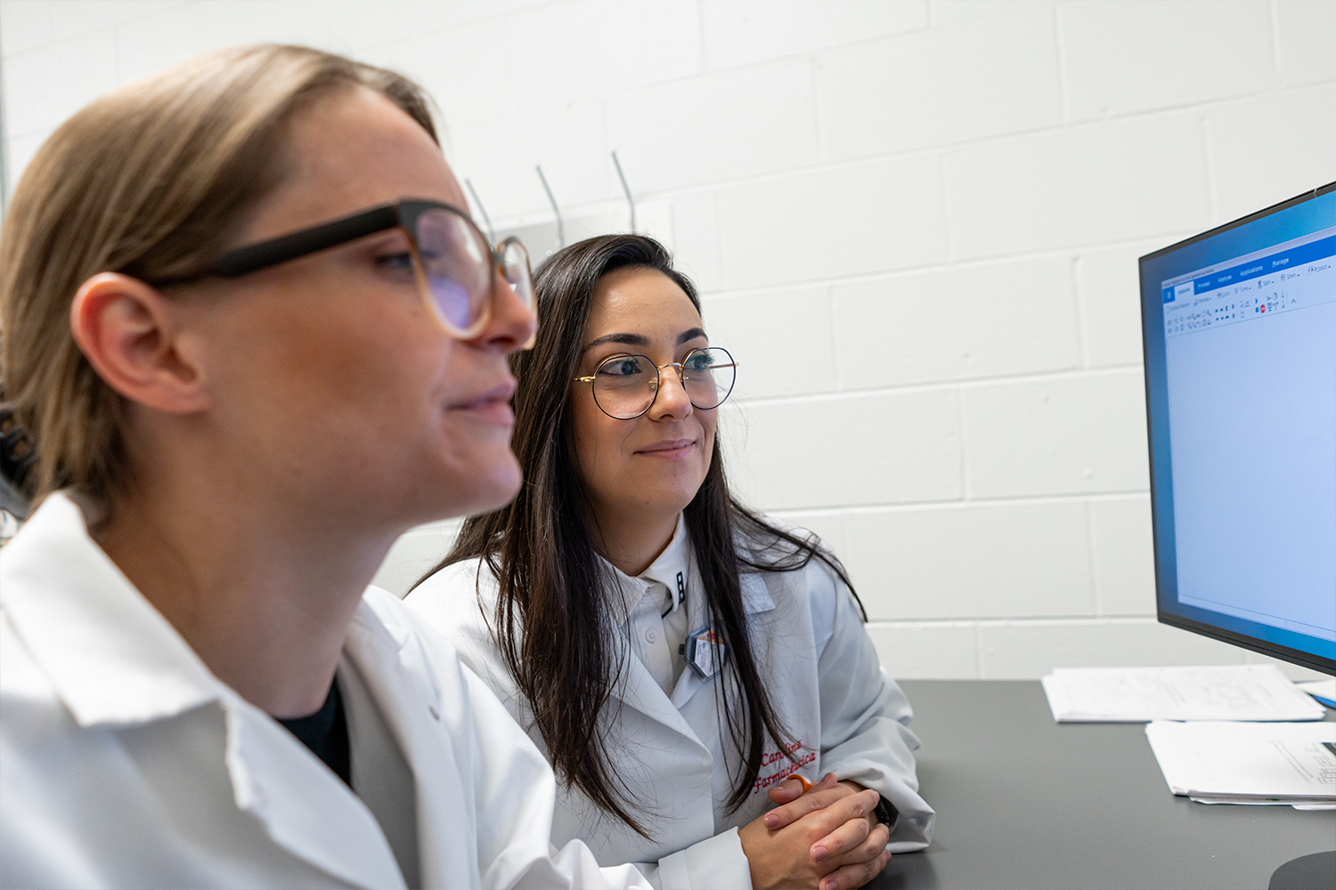 Two researchers looking at a monitor