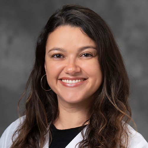 A headshot of Debora Barbosa Vendramini Costa wearing lab coat. 
