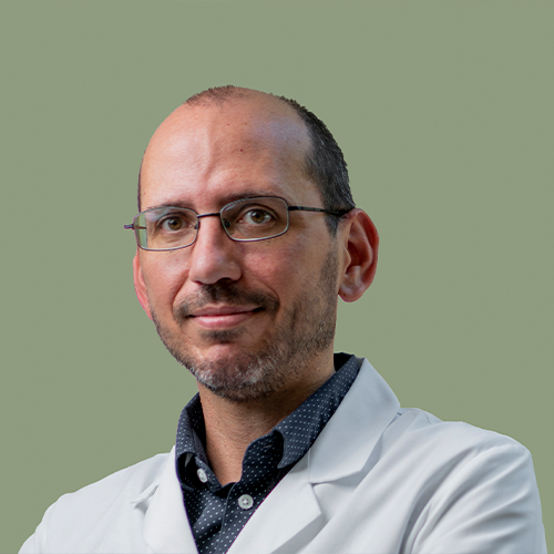 A headshot of Eric Mellon wearing glasses a lab coat. 