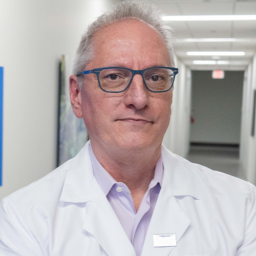 A headshot of Howard Crawford wearing glasses and a lab coat. 