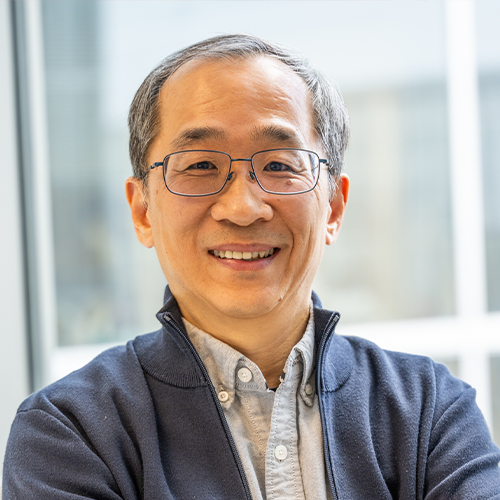 A headshot of Dohun Pyeon smiling wearing glasses and a blue dress shirt 