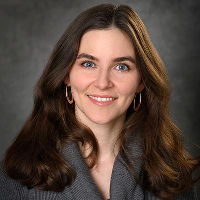 A headshot of Bonnie Harrington smiling wearing a gray sweater
